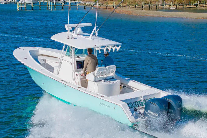 Slide: The Image of 2008 Regulator 32 Forward Seating boat cruising on blue water with dual Yamaha engines. - 2
