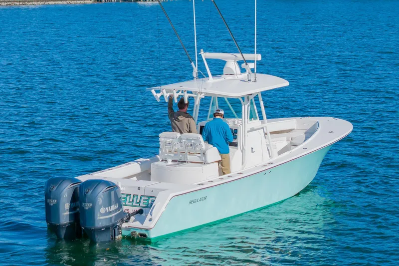 Slide: The Image of 2008 Regulator 32 Forward Seating boat with dual Yamaha engines on blue water. - 4