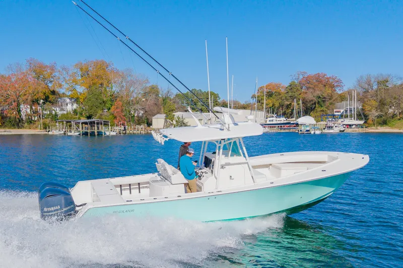 Slide: The Image of 2008 Regulator 32 Forward Seating boat cruising on a scenic lake with autumn trees. - 8