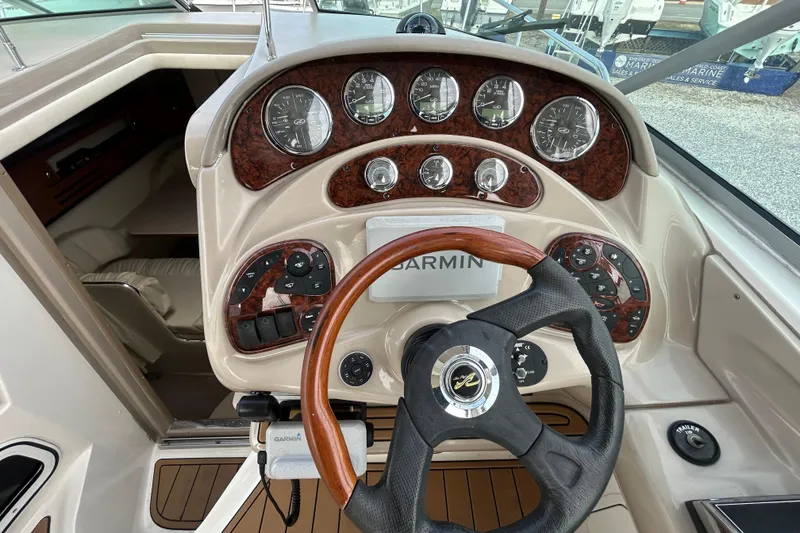 Slide: The Image of 2004 Sea Ray 280 Sundancer helm with Garmin navigation and wood-accented dashboard. - 15