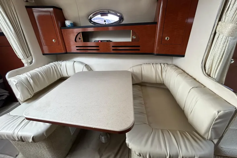 Slide: The Image of Interior of 2004 Sea Ray 280 Sundancer with cushioned seating and wooden cabinetry. - 26