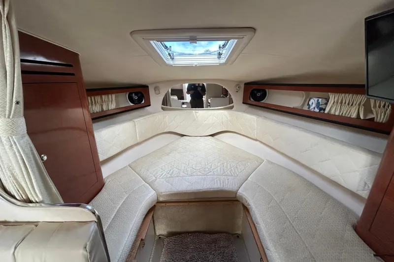 Slide: The Image of Interior cabin of 2004 Sea Ray 280 Sundancer with plush seating and wood accents. - 27