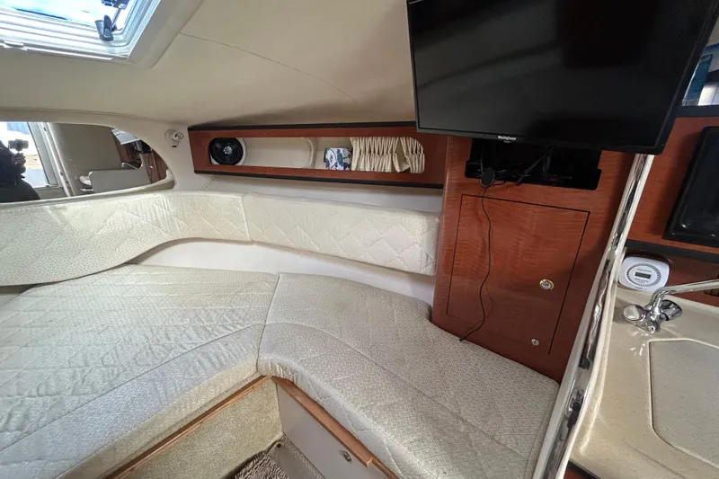 Slide: The Image of Interior of 2004 Sea Ray 280 Sundancer with cozy seating and mounted TV. - 29
