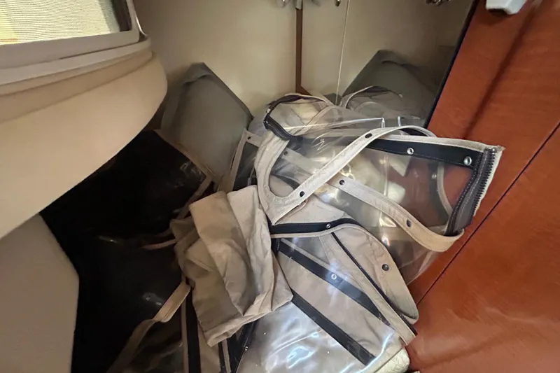 Slide: The Image of 2004 Sea Ray 280 Sundancer cabin with stored clear vinyl boat covers. - 34