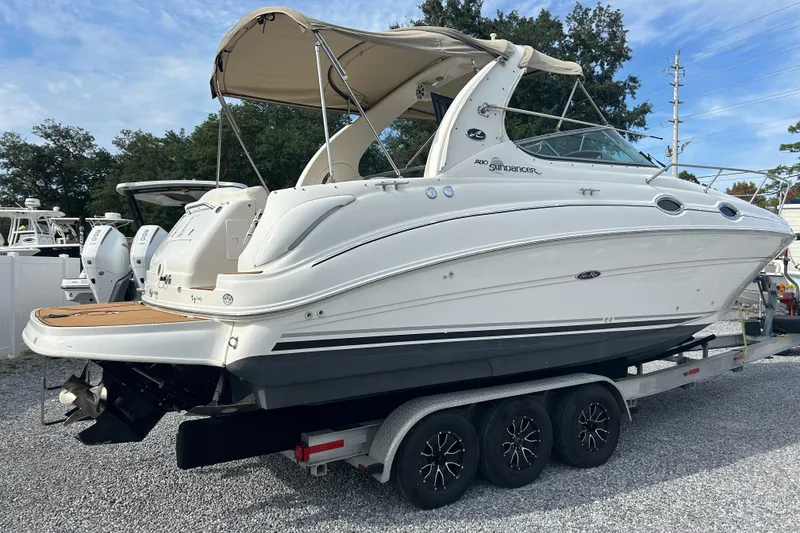 Slide: The Image of 2004 Sea Ray 280 Sundancer boat on trailer, side view with canopy, parked outdoors. - 4