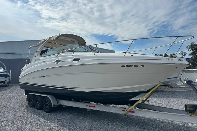 Slide: The Image of 2004 Sea Ray 280 Sundancer boat on trailer, parked outdoors under cloudy sky. - 6