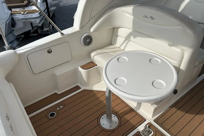 Slide: The Image of 2004 Sea Ray 280 Sundancer interior with seating and table, featuring wood-style flooring. - 8