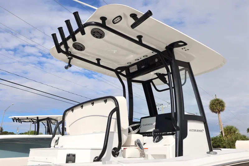 Slide: The Image of 2026 Sea Hunt Ultra 245 SE boat with T-top and rod holders under a blue sky. - 4