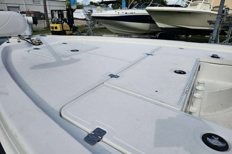 Slide: The Image of 2006 Triton 220 LTS boat deck with storage compartments and fishing rod holders. - 15