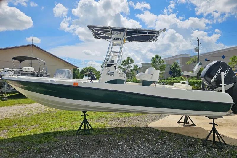 Slide: The Image of 2006 Triton 220 LTS boat with Mercury engine on display under a sunny sky. - 26