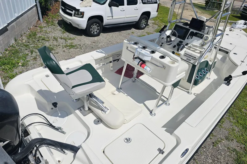 Slide: The Image of 2006 Triton 220 LTS boat interior with seating, console, and equipment, parked near a white vehicle. - 28