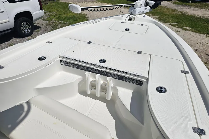 Slide: The Image of 2006 Triton 220 LTS boat deck with storage compartments and fishing rod holders. - 30
