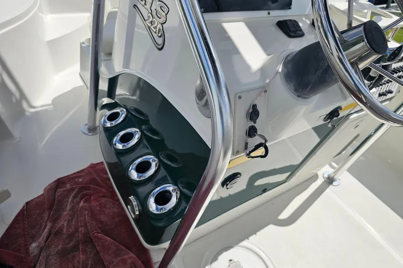 Slide: The Image of 2006 Triton 220 LTS boat console with steering wheel and rod holders. - 37