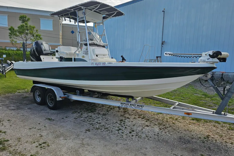 Slide: The Image of 2006 Triton 220 LTS boat on trailer, parked outdoors near blue building. - 4