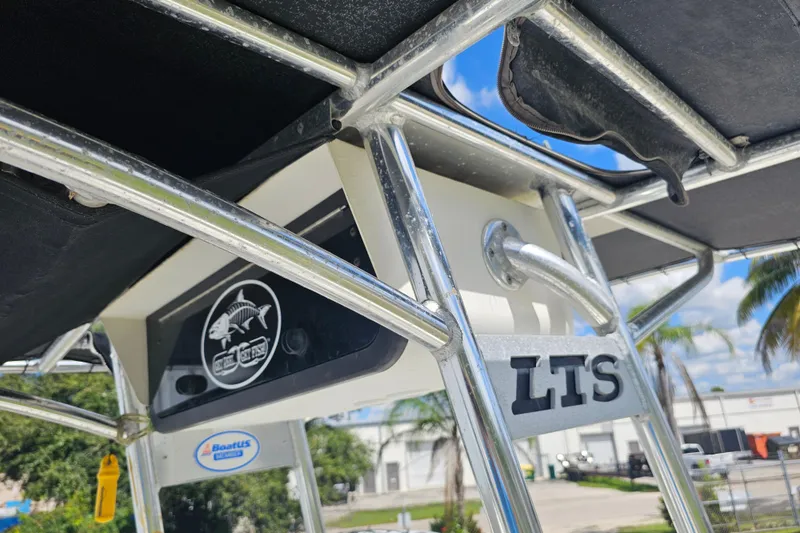 Slide: The Image of 2006 Triton 220 LTS boat with metal framework and logo, under a sunny sky. - 42