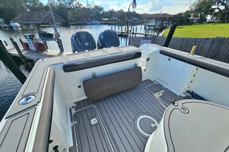 Slide: The Image of 2006 Polar 2700 Center Console boat at dock, featuring spacious deck and twin engines. - 6
