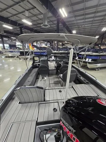 Slide: The Image of 2024 Vexus ADX180 boat with Mercury engine, showcased indoors, featuring spacious seating and canopy. - 5