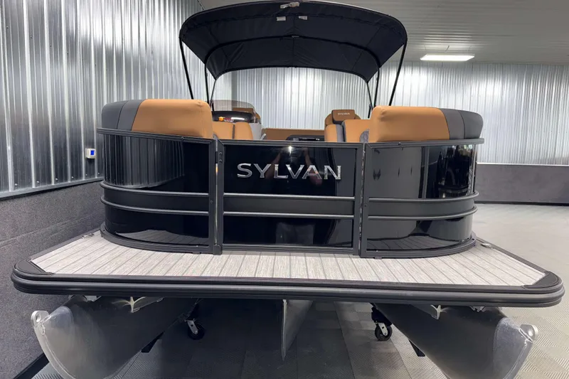 Slide: The Image of 2026 Sylvan L3 CLZ DH pontoon boat in showroom, featuring sleek black design and tan seating. - 22