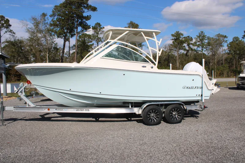 The Image of 2026 Sailfish 245 DC boat on trailer, parked outdoors, clear sky background. - 0