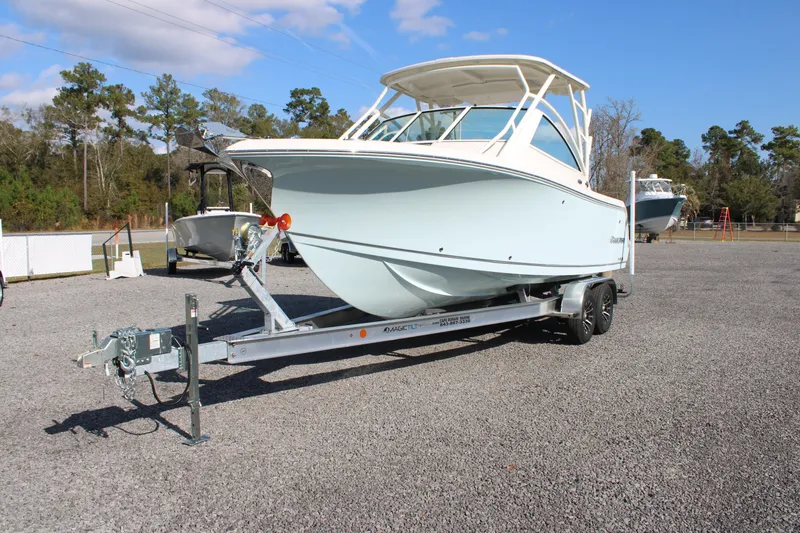 Slide: The Image of 2026 Sailfish 245 DC boat on trailer in outdoor setting. - 2