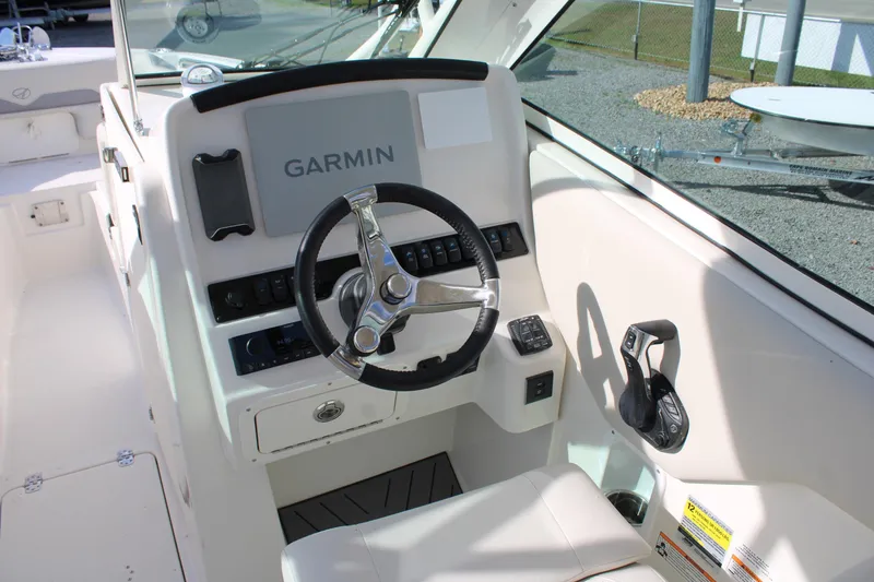 Slide: The Image of 2026 Sailfish 245 DC boat helm with Garmin navigation system and steering wheel. - 30