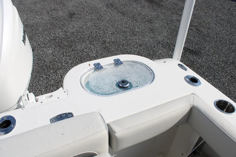 Slide: The Image of Sailfish 245 DC 2026 boat livewell and seating area with cup holders. - 34