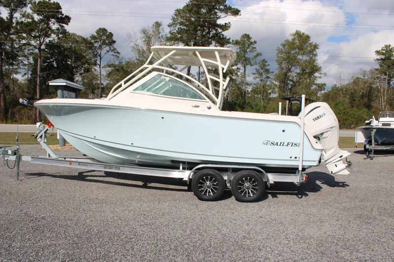 Slide: The Image of 2026 Sailfish 245 DC boat on trailer, parked outdoors, side view. - 39