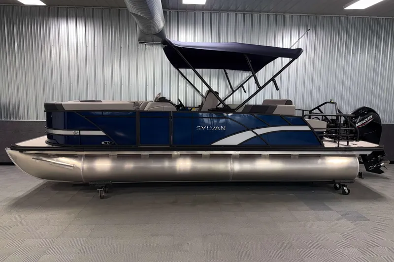 Slide: The Image of 2026 Sylvan L3 CLZ DH pontoon boat with blue exterior and canopy in showroom. - 22