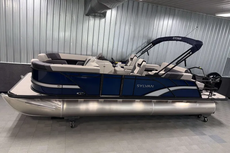 The Image of 2026 Sylvan L3 CLZ DH pontoon boat in showroom, featuring sleek design and modern seating. - 0
