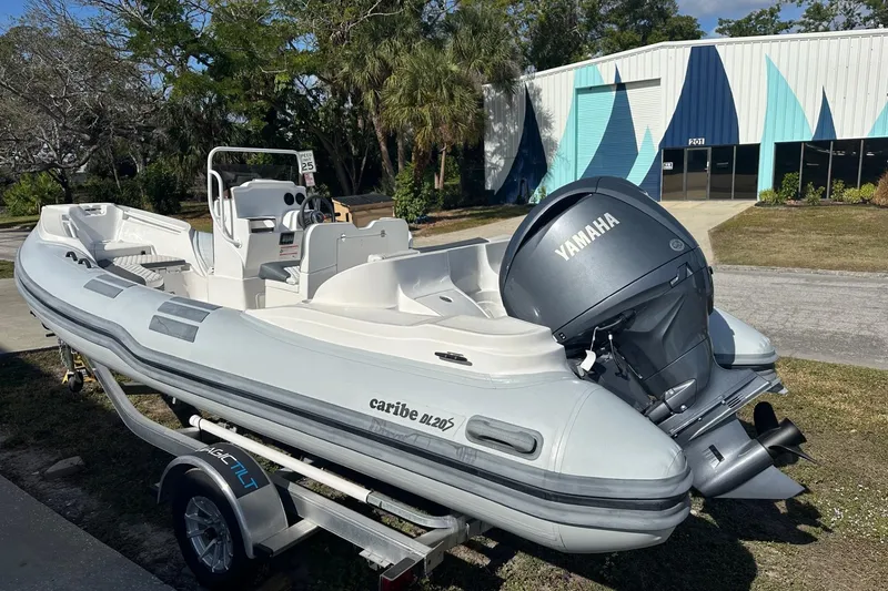 Slide: The Image of 2024 Caribe DL-20S inflatable boat with Yamaha engine on trailer, parked outdoors. - 3