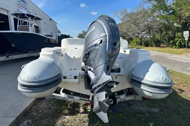 Slide: The Image of 2024 Caribe DL-20S inflatable boat with Yamaha 150 outboard motor, parked outdoors. - 4