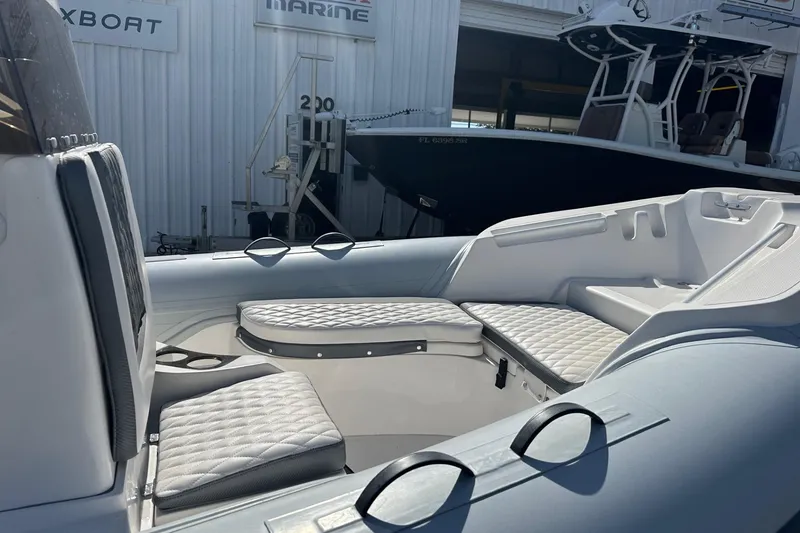 Slide: The Image of 2024 Caribe DL-20S boat interior with quilted seating, docked at a marine facility. - 7
