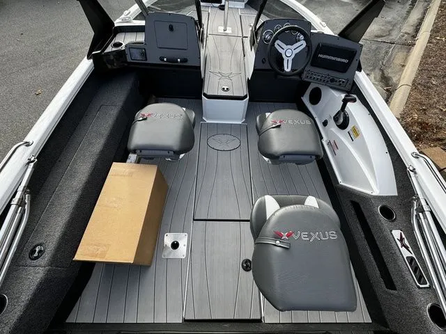 Slide: The Image of 2024 Vexus ADX190 boat interior with seating, steering console, and a cardboard box on the floor. - 5