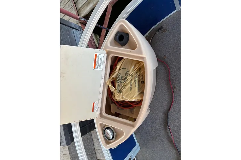 Slide: The Image of 2017 Sun Tracker Fishin' Barge 22 DLX storage compartment with items inside. - 10