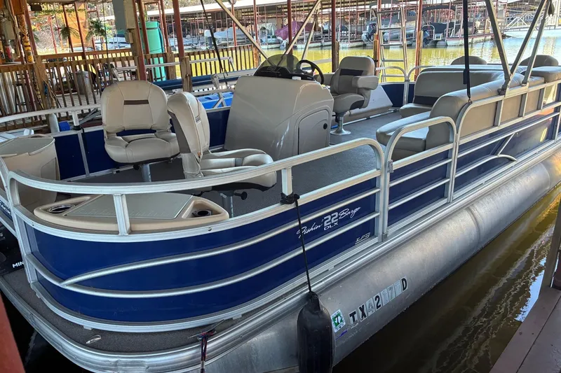 Slide: The Image of 2017 Sun Tracker Fishin' Barge 22 DLX pontoon boat docked in marina. - 2