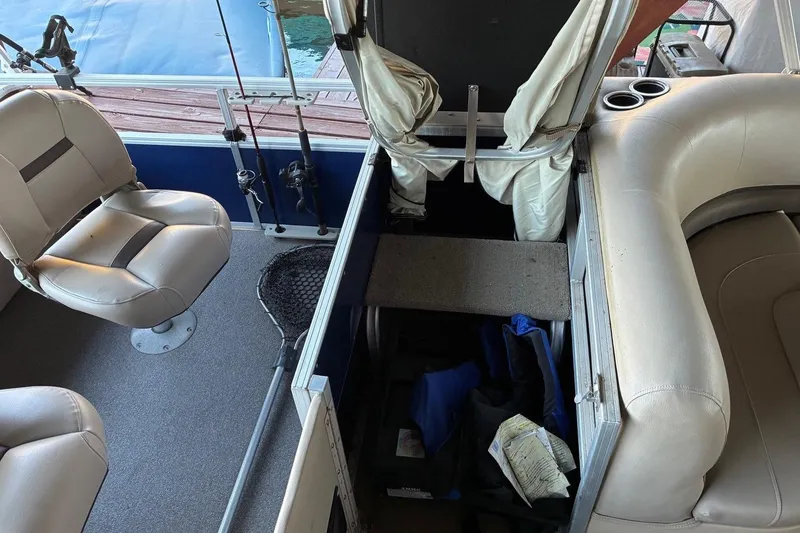 Slide: The Image of 2017 Sun Tracker Fishin' Barge 22 DLX interior with storage, seating, and fishing gear. - 7
