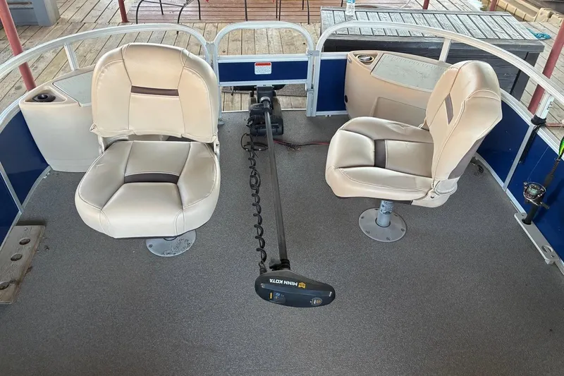 Slide: The Image of 2017 Sun Tracker Fishin' Barge 22 DLX interior with two swivel seats and trolling motor. - 8