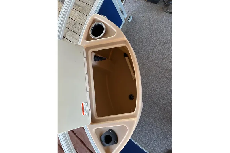 Slide: The Image of 2017 Sun Tracker Fishin' Barge 22 DLX storage compartment with cup holders and beige interior. - 9