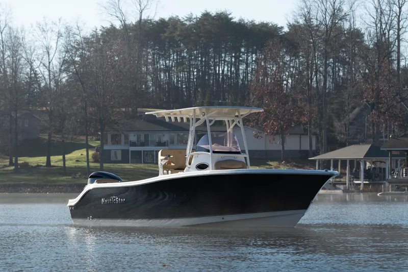The Image of 2020 NauticStar 2602 Legacy boat on a serene lake with wooded background. - 1