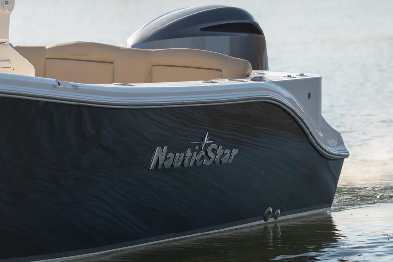 Slide: The Image of 2020 NauticStar 2602 Legacy boat on water, showcasing sleek design and branding. - 3