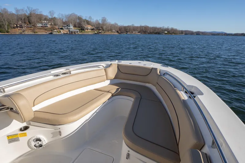 Slide: The Image of 2020 NauticStar 2602 Legacy boat with beige seating on a calm lake. - 4