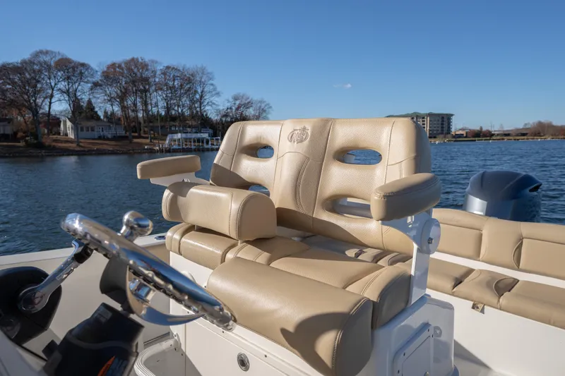 Slide: The Image of 2020 NauticStar 2602 Legacy boat with tan seating on a sunny day by the water. - 6