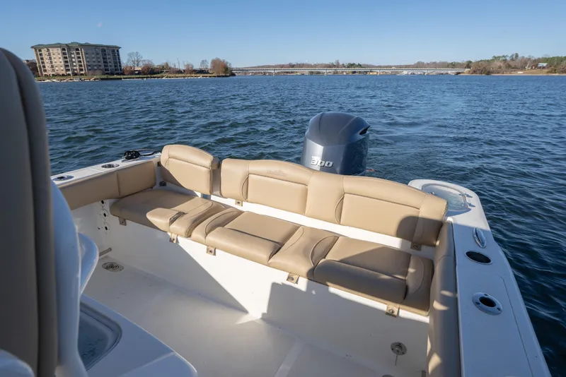 Slide: The Image of 2020 NauticStar 2602 Legacy boat interior with seating and outboard motor on a lake. - 8