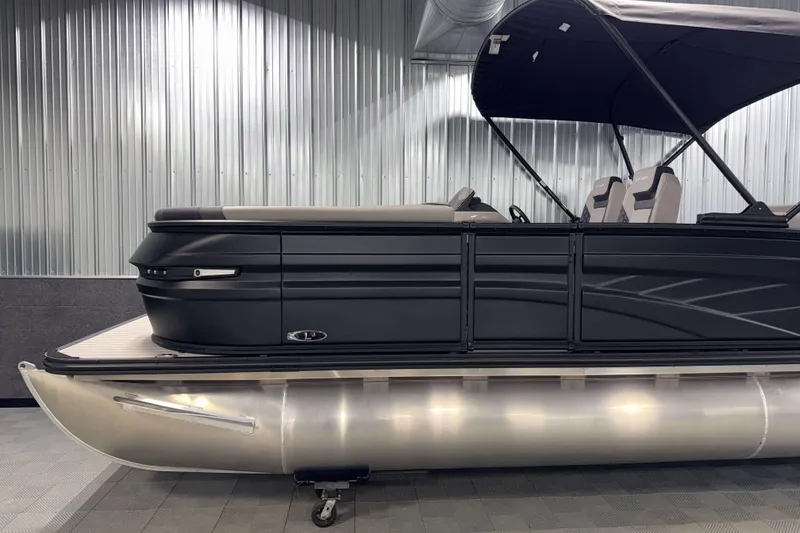 Slide: The Image of 2026 Sylvan L3 CLZ DH Platinum pontoon boat with sleek black design in showroom. - 23