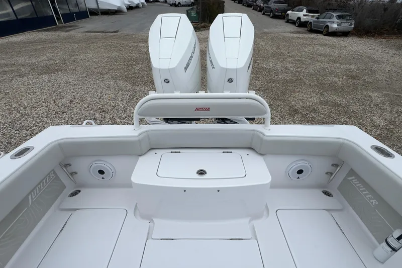 Slide: The Image of 2024 Jupiter 32 FS boat with dual Mercury engines, parked on gravel. - 12