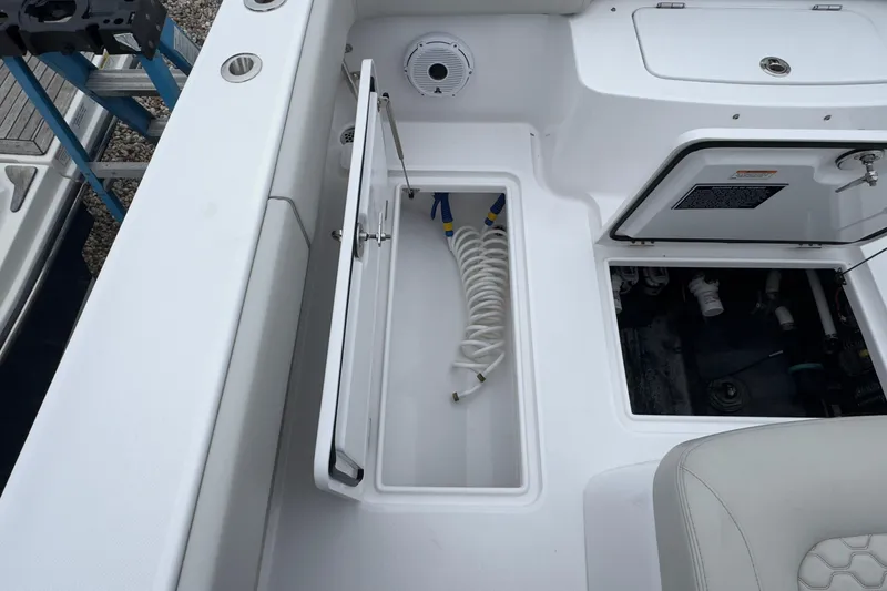Slide: The Image of 2024 Jupiter 32 FS boat interior with storage compartments and coiled hose. - 14