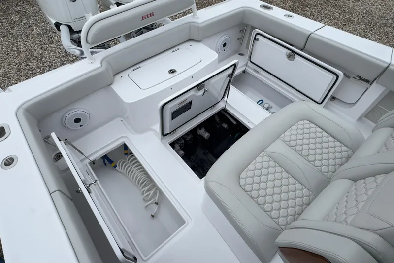 Slide: The Image of 2024 Jupiter 32 FS boat interior with storage compartments and cushioned seating. - 15