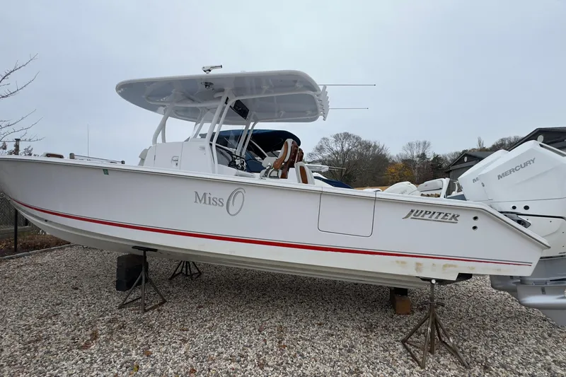 Slide: The Image of 2024 Jupiter 32 FS boat on gravel, featuring Mercury engines and sleek design. - 2
