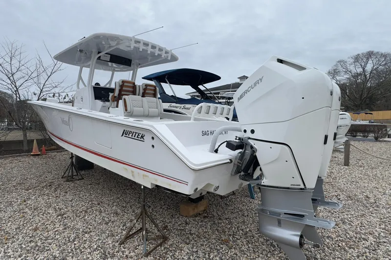 Slide: The Image of 2024 Jupiter 32 FS boat with Mercury outboard engines on gravel lot. - 4