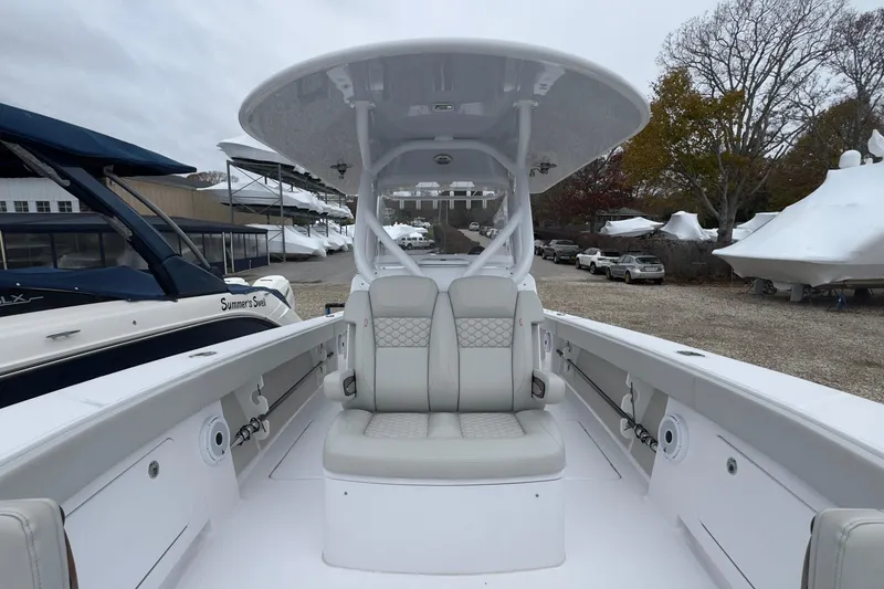 Slide: The Image of 2024 Jupiter 32 FS boat interior with seating and console, docked outdoors. - 42